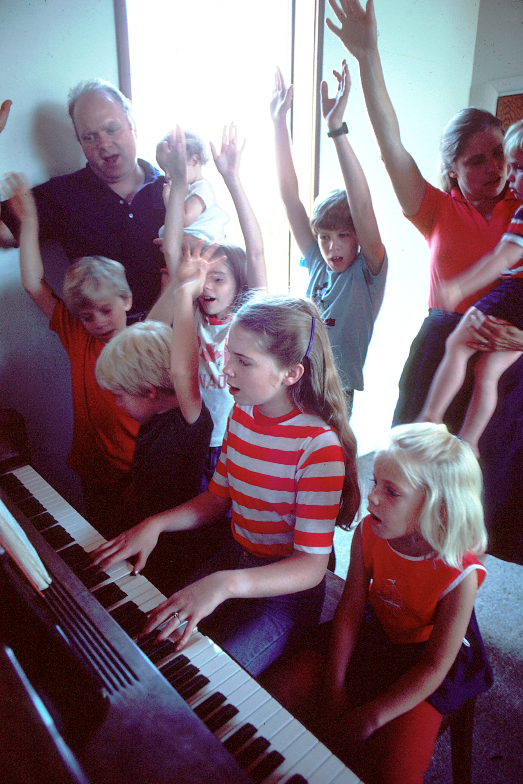Family gathered around piano