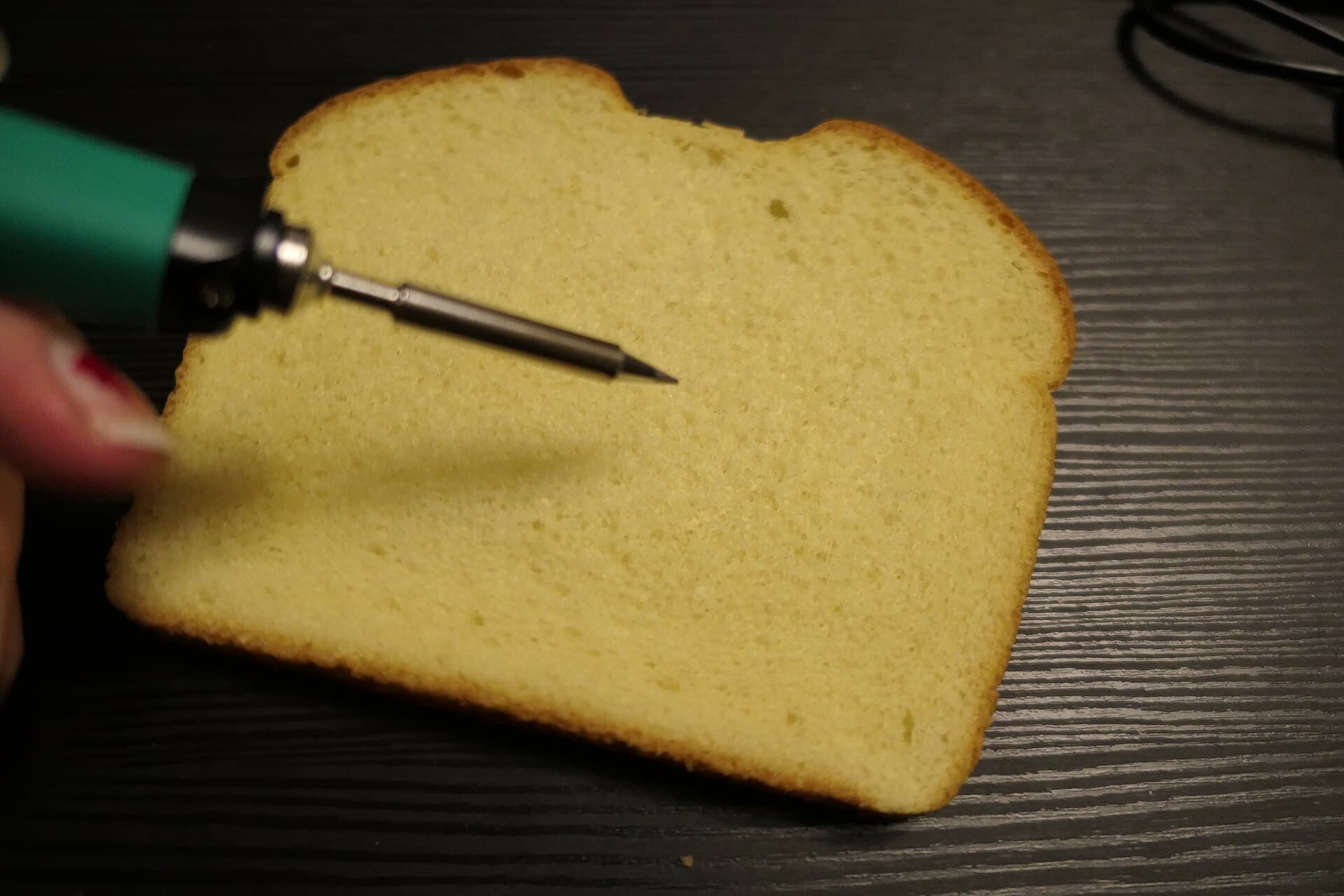 Bread on black table with soldering iron