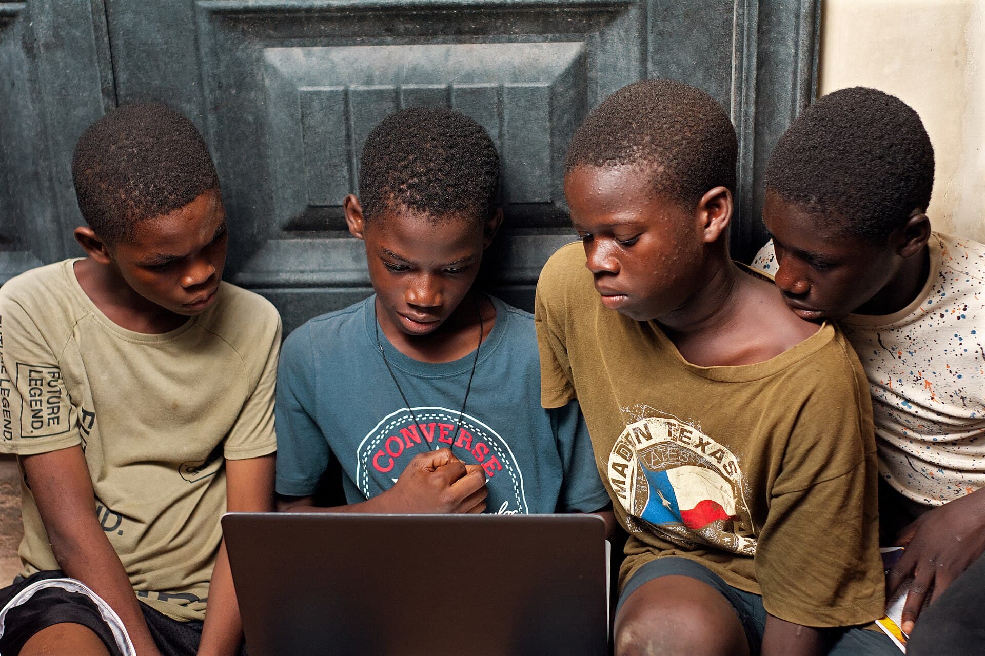 A group of boys using a laptop