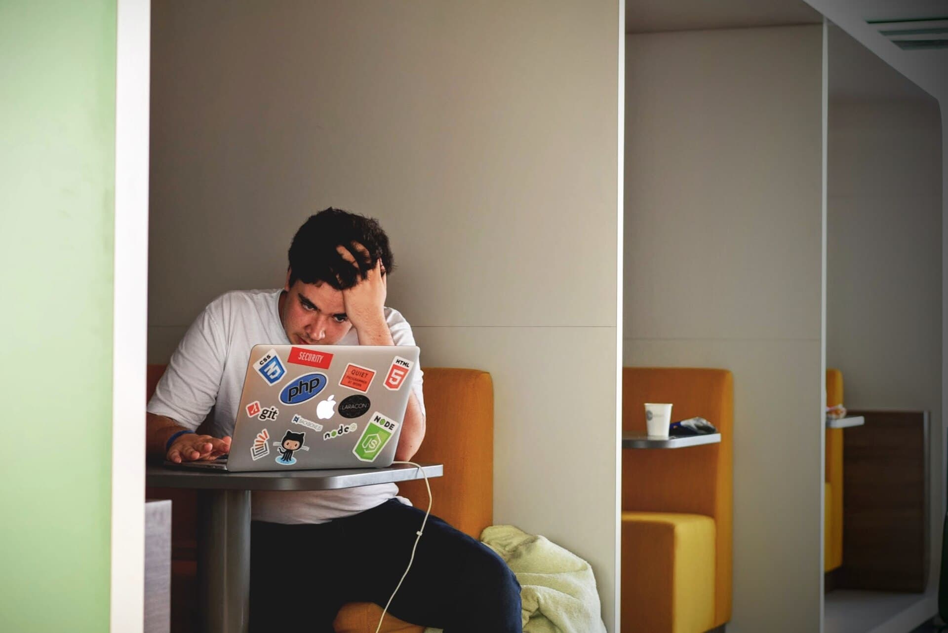 Man wearing white top using MacBook