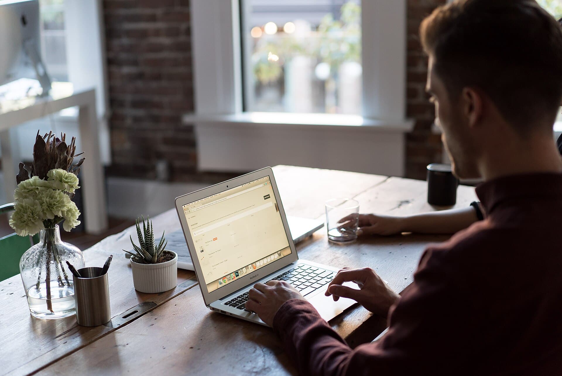 Man at a laptop in an office (Unsplash)