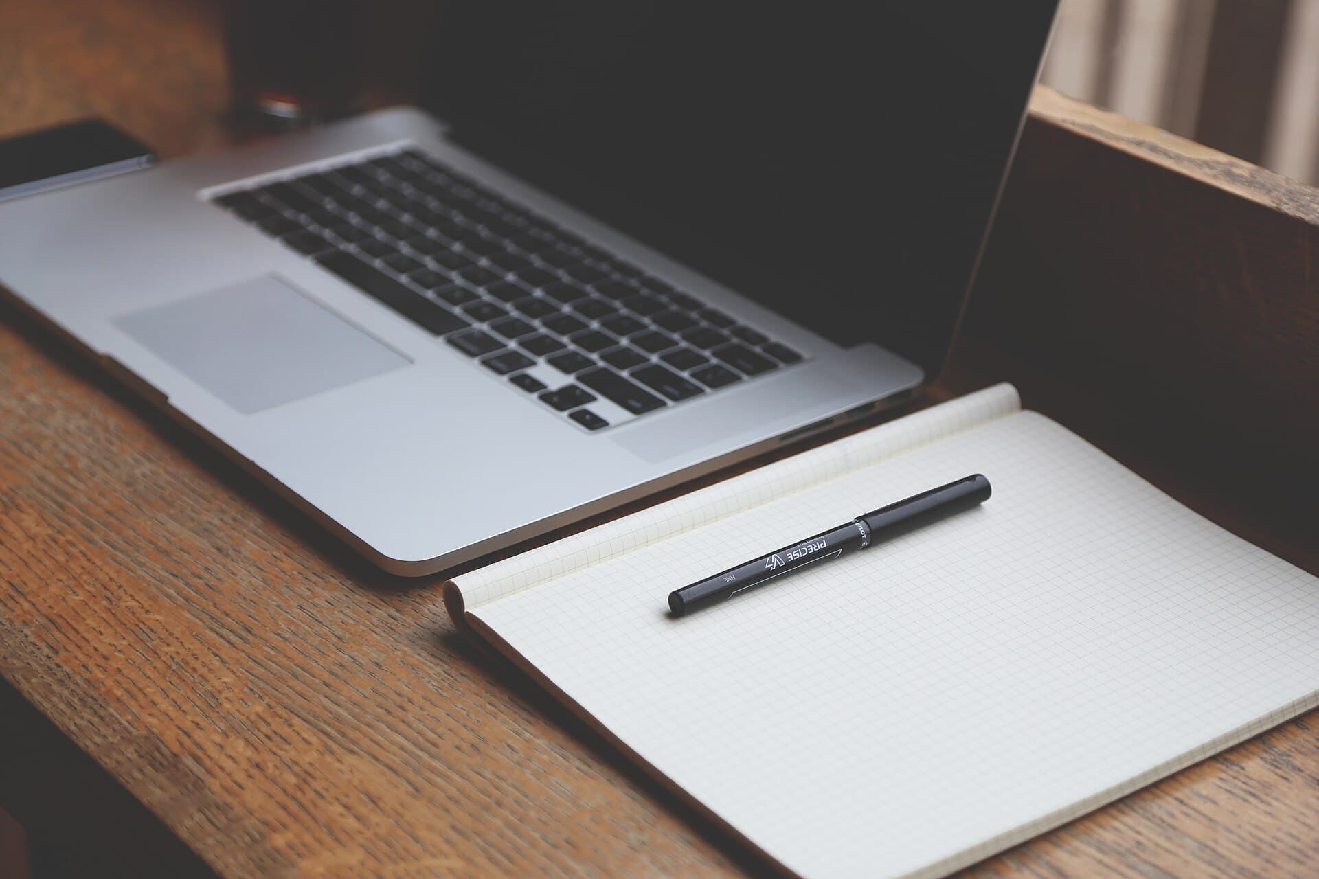 A laptop and a notebook on the wooden table (Pixabay)