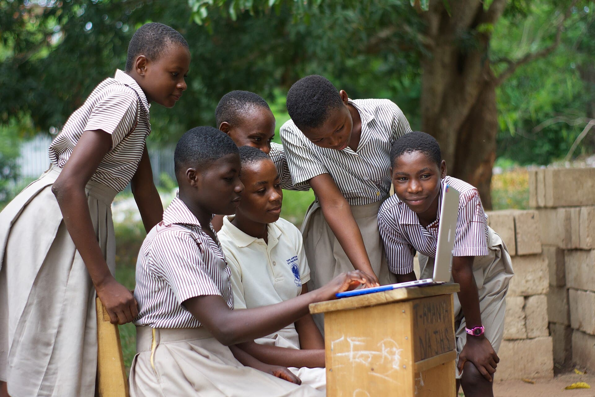 A group of students using a computer laptop