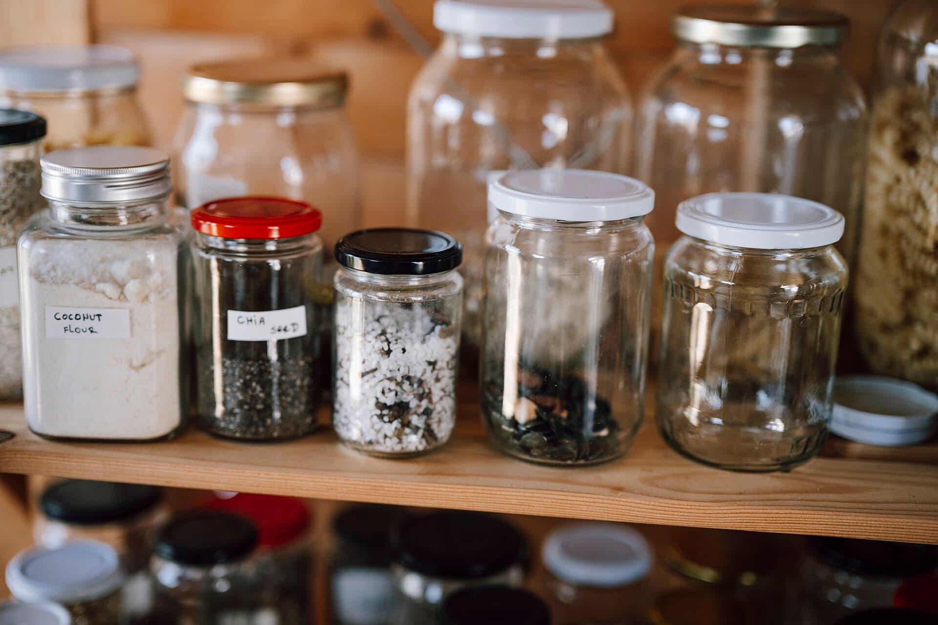 Container storage at a kitchen pantry with different types of food items in jars and bottles at home