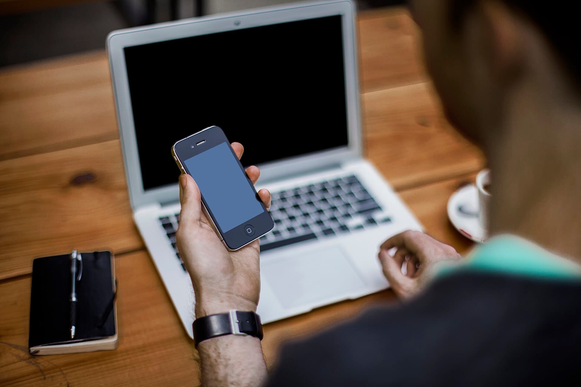 Man with smartphone and laptop (Unsplash)